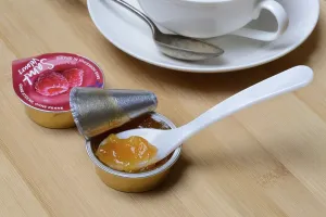 Environmentally Friendly Packaging Prints: Jam in portion pack with spoon, jam