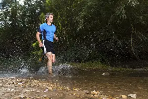 Recreational Activity Germany Prints: Jogger running through a stream
