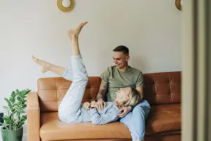 Caucasian Couple On Sofa Prints: Junger kaukasischer Mann