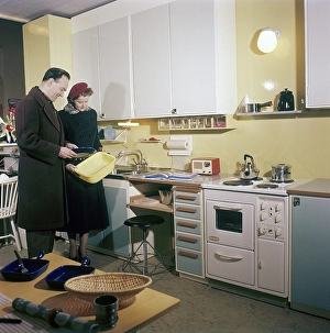 Vintage Kitchen Appliances Prints: In the kitchen 1950s. A young couple in a kitchen designed and with objects