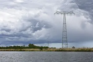 Northern German Scenery Prints: Landscape with high power pole under dramatic waterside cloud formations