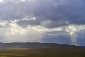 Northern Europe Nature Scenery Prints: Landscape with rolling hills and rays of light breaking through dramatic clouds