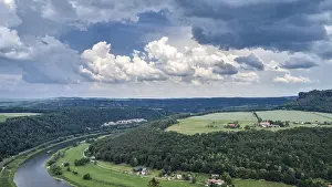 Dramatic European Skies Prints: Landscape with a winding river and vast fields under a dramatic sky