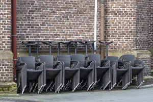 Images Dated 16th March 2024: Stacked Chairs in Front of Brick Wall Print