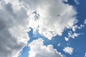 Low Angle Cloud View Prints: Large white clouds against a blue sky