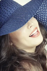 Studio Portrait Woman Prints: Laughing lady with blue hat on a studio background