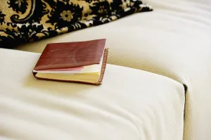 Time Management Tools Prints: A leather-bound notebook lying on a sofa