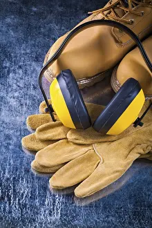 Industrial Safety Gear Prints: Leather work boots, protective gloves and headphones for noise reduction on scratched metal surfaces Design concept