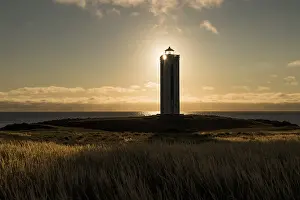 Atmospheric Coastal Scene Prints: Lighthouse in the backlight, Kalfshamarsvik