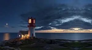 Sunset Rock Formation Prints: Lighthouse surrounded by rocks at night