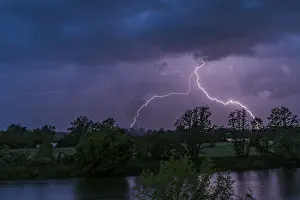 Dark Clouds Europe Prints: Lightning during a night-time thunderstorm with dark clouds and dramatic atmosphere