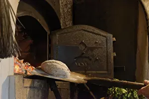 European Pastry Photography Prints: Loaf of bread is placed in the stone oven