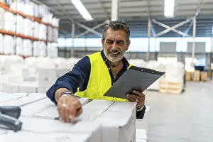 Supply Chain Operations Prints: Logistics manager smiling while using a barcode scanner