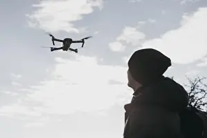 Remote Controlled Aircrafts Prints: Low angle man watching drone