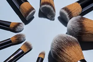 Cosmetic Product Display Prints: Make up brush sets arranged in a circle on blue background