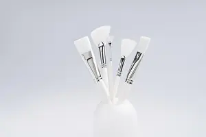 Full Frame Beauty Shot Prints: Make up brushes of different size and type in a glass against light blue background