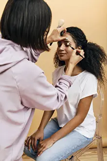 Studio Beauty Shot Prints: Makeup artist applying eye make up on model in studio