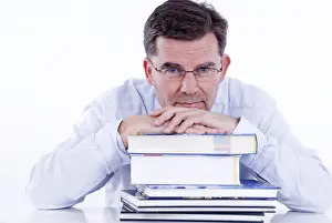 Pensive Businessman Prints: Man, 50+, leaning on a stack of books