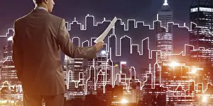Caucasian Male Professional Prints: Man architect or engineer presenting construction concept and holding documents in hand