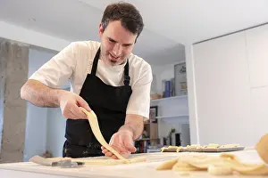 Breakfast Bread Nutrition Prints: A man baking croissants picking up the triangular cuts from the puff pastry