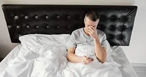 Nighttime Relaxation Prints: Man bed using mobile