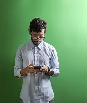 Young Man On Phone Prints: Man checking his cell phone isolated