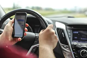 Road Traffic Accident Prints: Man checking his text messages while driving