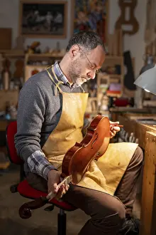 Images Dated 3rd December 2024: Man Examining a Violin Print