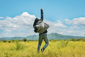 Farmland Landscape Photo Prints: Man from back jumping in a nice field