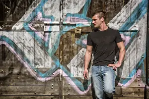 Graffiti Art Prints: A man leaning against a wall with graffiti on it