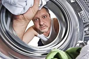 Washing Machine Interior View Prints: Man loading cloths to washing machine