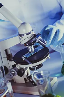 Scientist In Lab Prints: Man is looking into the ocular of microscope