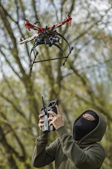 Drone Aerial Photography Prints: Man in mask operating a drone with remote control
