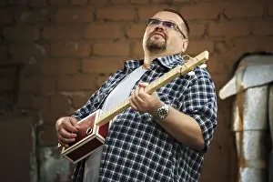 Cigar Box Guitar Prints: Man playing his three string cigar box guitar
