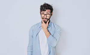 Hispanic Ethnicity Model Prints: Man rubbing his beard with an expression of doubt