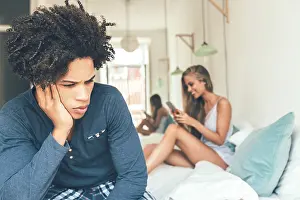 Couple On Bed Prints: A man sits on a bed looking concerned