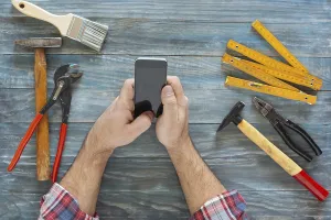 Carpenter At Work Prints: Man working on a DIY project with his phone