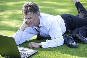 Caucasian Male Professional Prints: Manager working on notebook in park