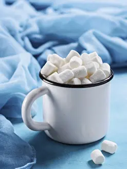 Blue Background Image Prints: Marshmallows in cup on blue background with copyspace