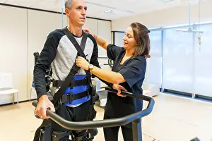Mechanical Exoskeleton Prints: Mechanical exoskeleton. Female physiotherapy medical assistant with disabled person lifted with robotic skeleton