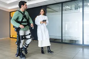 Medical Innovation Prints: Mechanical exoskeleton, female doctor physiotherapist walking with disabled person helped by robotic skeleton
