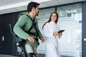 Mechanical Exoskeleton Prints: Mechanical exoskeleton, female doctor physiotherapist with disabled person with robotic skeleton in rehabilitation
