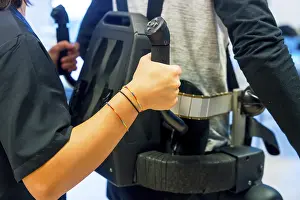 Mechanical Exoskeleton Prints: Mechanical exoskeleton. Female physiotherapy medical assistant helping disabled person with robotic skeleton to walk