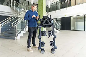 Exoskeleton Technology Prints: Mechanical exoskeleton computer engineer looking at the robot with a tablet