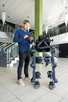 Mechanical Exoskeleton Prints: Mechanical exoskeleton computer engineer looking at the robot with a tablet