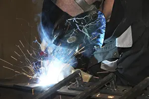 Industrial Equipment Prints: Metalworker during welding work in his workshop