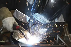 Industrial Equipment Prints: Metalworker during welding work in his workshop