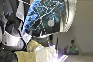 Industrial Equipment Prints: Metalworker during welding work in his workshop