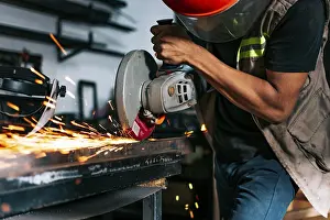 Handicraft Industry Prints: Metalworking professional using an angle grinder in the workshop