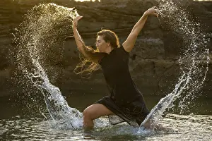 Prints of Middle-aged woman dancing and throwing water in the air, Maioris beach, llucmajor, Majorca, Balearic Islands, Spain Dance Prints: Middle-aged Woman Dancing with Water, Maioris Beach Print